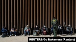 Migrantes de Venezuela y Cuba detenidos por la patrulla fronteriza de EEUU después de cruzar la frontera desde México en Yuma, Arizona, el 17 de febrero de 2022.
(REUTERS/Go Nakamura).
