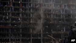 Bomberos extinguen un incendio en un centro comercial tras un ataque en Kiev, Ucrania, el lunes 21 de marzo de 2022. (AP Foto/Felipe Dana)