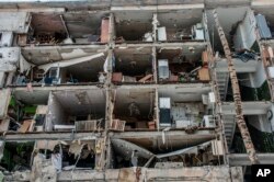 Un edificio de apartamentos se ve destruido por ataques en Járkiv, Ucrania, el domingo 13 de marzo de 2022. (AP Foto/Andrew Marienko)
