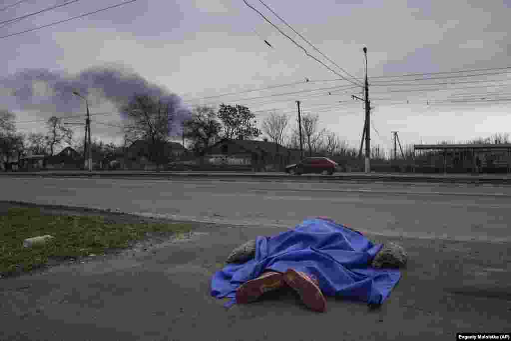 Una lona azul cubre el cad&#225;ver de una persona en una calle de Mari&#250;pol (Ucrania) el 7 de marzo.