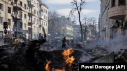 Bomberos apagan llamas ante un edificio de apartamentos tras un ataque ruso en Járkiv, la segunda ciudad más grande de Ucrania, el lunes 14 de marzo.