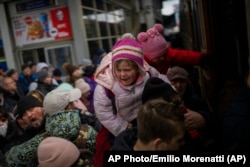 Ucranianos tratando de subir a un tren que los lleve desde Kyiv a Lviv.