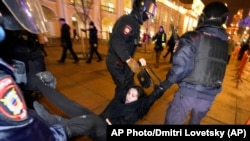 La policía rusa detiene a una manifestante en una protesta contra la invasión a Ucrania en St. Petersburg.