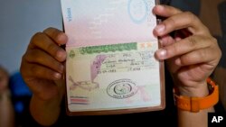 Migrante cubana muestra su pasaporte sellado con una extensión de visa costarricense