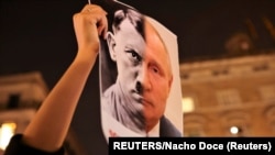Una recreación de los rostros de Putin y Hitler en una protesta en Barcelona, España contra la invasión de Rusia a Ucrania.