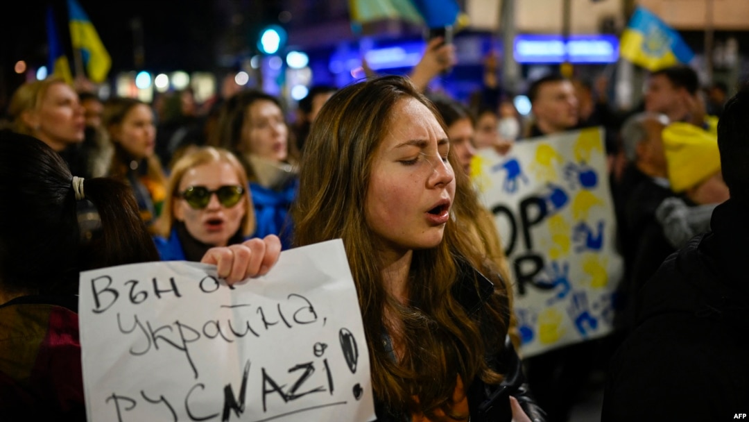 Una mujer sostiene un cartel que dice "Fuera de Ucrania, nazis rusos" durante una manifestación para apoyar a Ucrania. 