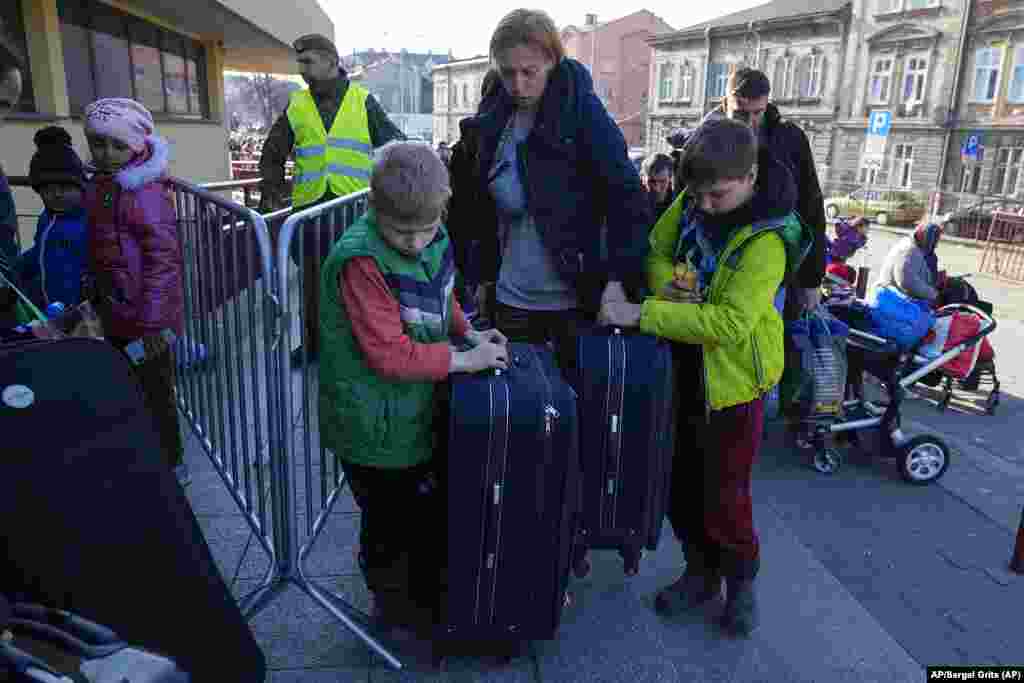 Refugiados con niños esperan ser transportados en una estación de trenes en Przemysl, Polonia. Foto: AP/Sergei Grits.