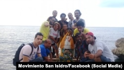 Artistas y activistas cubanos posan junto a una imagen de la Virgen de la Caridad del Cobre en el Malecón de La Habana. (Movimiento San Isidro/Facebook)