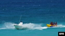 Varios turistas dan un paseo en una balsa popularmente conocida como "plátano"