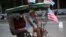 Un cubano exhibe una bandera de EEUU en su bicitaxi, en una calle de La Habana.
