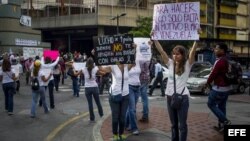 Un grupo de personas opositores al Gobierno del presidente venezolano, Nicolás Maduro, muestra unos carteles con mensajes de protesta en la avenida Francisco de Miranda hoy, 20 de marzo de 2014, en Caracas (Venezuela).