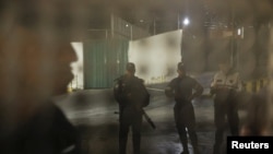 Agentes de la Policía Nacional Bolivariana permanecen firmes mientras se libera a prisioneros en el Centro de Detención de la Zona 7 de la Policía Nacional. REUTERS/Leonardo Fernandez Viloria