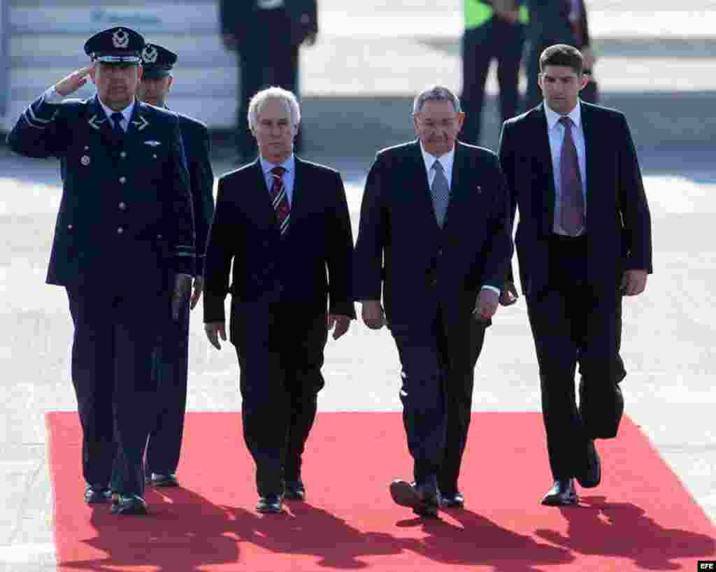 El presidente de Cuba, Raúl Castro (2 d), llega el viernes 25 de enero al Aeropuerto Internacional de Santiago de Chile.