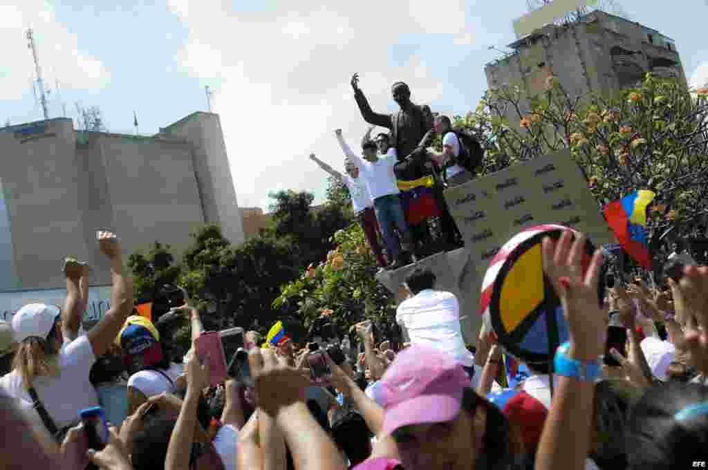 El dirigente opositor venezolano Leopoldo López (c-arriba) se dirige a sus seguidores antes de entregarse a miembros de la Guardia Nacional (GNB, policía militarizada)