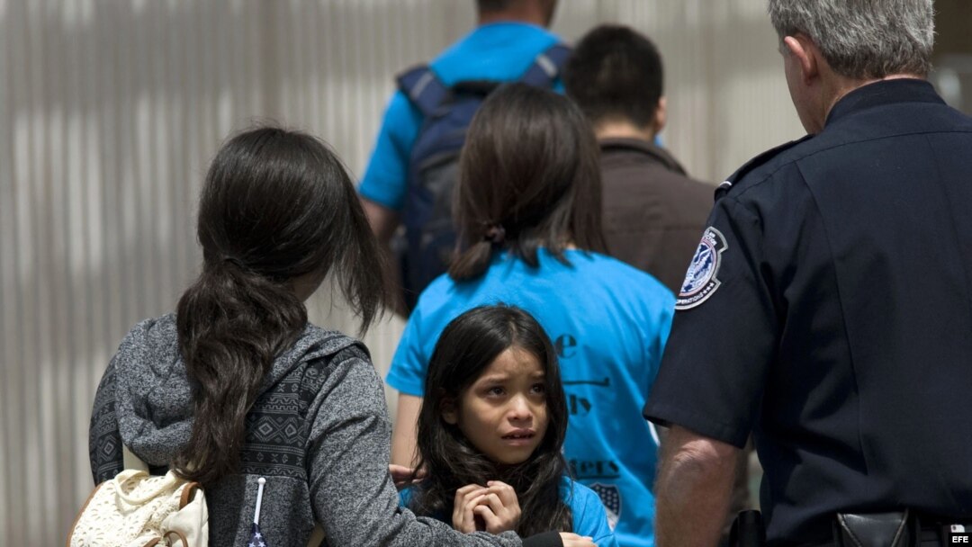 Mahalia Velazco (c), de 8 años, observa a un oficial estadounidense de fronteras, mientras ingresa a Estados Unidos con su familia por la garita de San Ysidro en la frontera entre EEUU y Tijuana, México.