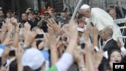 El papa Francisco bendice a un bebé a su llegada al rezo del Ángelus desde el balcón central del Palacio Arzobispal de San Joaquín en Río de Janeiro, el 26 de julio de 2013. 