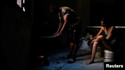 Jesús Rodríguez y su esposa, Yaliet Iglesias, durante un apagón general el 21 de marzo de 2026. REUTERS/Norlys Pérez