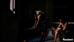 Una pareja de cubanos enciende carbón para cocinar en medio del colapso de la red eléctrica. ( Reuters/Norlys Perez)