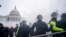 Partidarios de Trump intentan atravesar una barrera policial en el Capitolio de Washington. (AP/Julio Cortez).