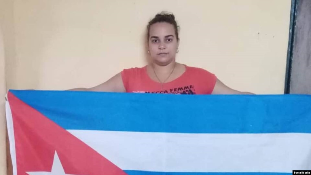 Irina León Valladares, de la Fundación Vueltabajo por Cuba, portando el estandarte nacional bajo la campaña "La bandera es de todos". (Facebook).