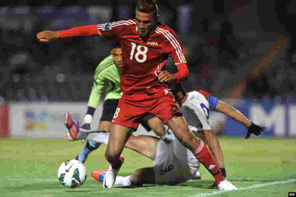El jugador de Cuba Abel Martínez (frente) disputa el balón con Gabriel Leiva (atrás) de Costa Rica durante el partido de cuartos de final de la eliminatoria de la Concacaf para el Mundial Sub'20 de Turquía en el Estadio Universitario de la BUAP, en Puebla