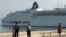 Dos policías observan la entrada de un crucero turístico en la bahía de La Habana./ Foto de archivo