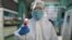 Una técnica de salud se dispone a tomarle la temperatura en Wuhan a un fotógrafo de la agencia AFP (Héctor Retamal/AFP).