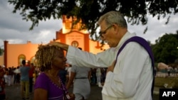 Un sacerdote bendice a un peregrino durante la procesión a El Rincón en adoración a San Lázaro, el 16 de diciembre de 2019. (Yamil Lage/AFP).