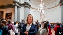 Cecilie Hollberg, directora de la Galería de la Academia posa delante de la estatua de mármol blanco “David”, de Miguel Ángel, en Florencia, Italia, el 28 de marzo de 2023 (AP Foto/Alessandra