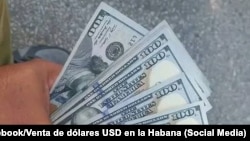 Un cubano muestra billetes de 100 dólares.
