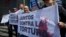 Opositores al régimen de Nicolas Maduro en Venezuela portan un cartel que reza: "Juntos contra la tortura", frente a la oficina de la ONU en Caracas.