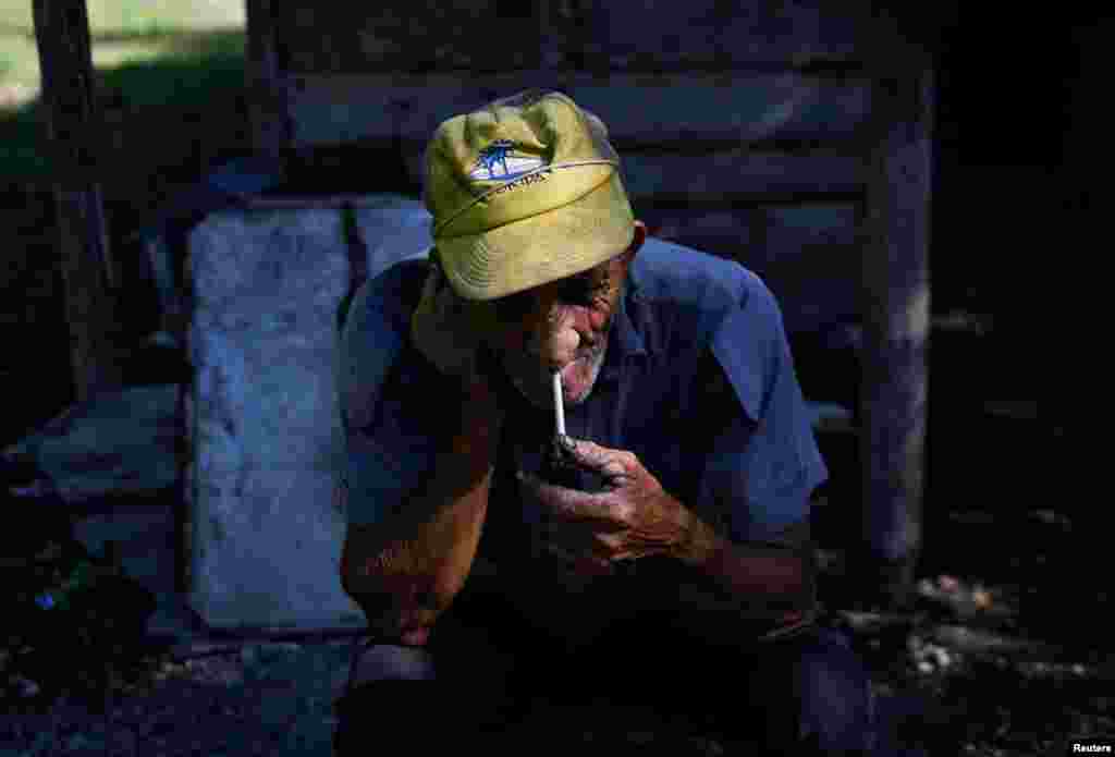 Miguel Cova, de 72 años, fuma su pipa tras elaborar carbón, en Palpite, Ciénaga de Zapata, Cuba, el 7 de abril de 2026. REUTERS/Norlys Perez