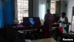 Trabajadores en un taller de reparaciones en La Habana, Cuba, escuchan un discurso de Miguel Díaz-Canel transmitido en la televisión cubana. 