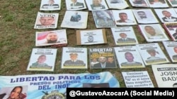 Un cartel muestra fotografías de presos políticos venezolanos en una protesta de familiares frente a la embajada de EEUU en Caracas.