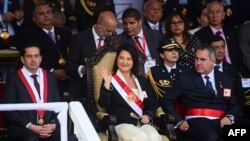La presidenta de Perú, Keiko Fujimori, saluda desde la tribuna junto al presidente del Senado peruano, Miguel Ángel Torres (izq.), y su ministro de Defensa, Rafael Belaúnde (der.)