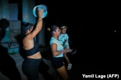 Mujeres protestan contra los apagones en un barrio de La Habana sonando cazuelas, el domingo 20 de octubre de 2024. (Yamil Lage/ AFP)