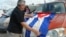 Un hombre coloca una bandera de cuba en su vehículo el 6 de junio de 2015, cuando unos 300 exiliados cubanos se concentraron en Miami.