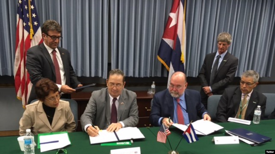 Funcionarios de EEUU y Cuba firman el acuerdo en Washington.