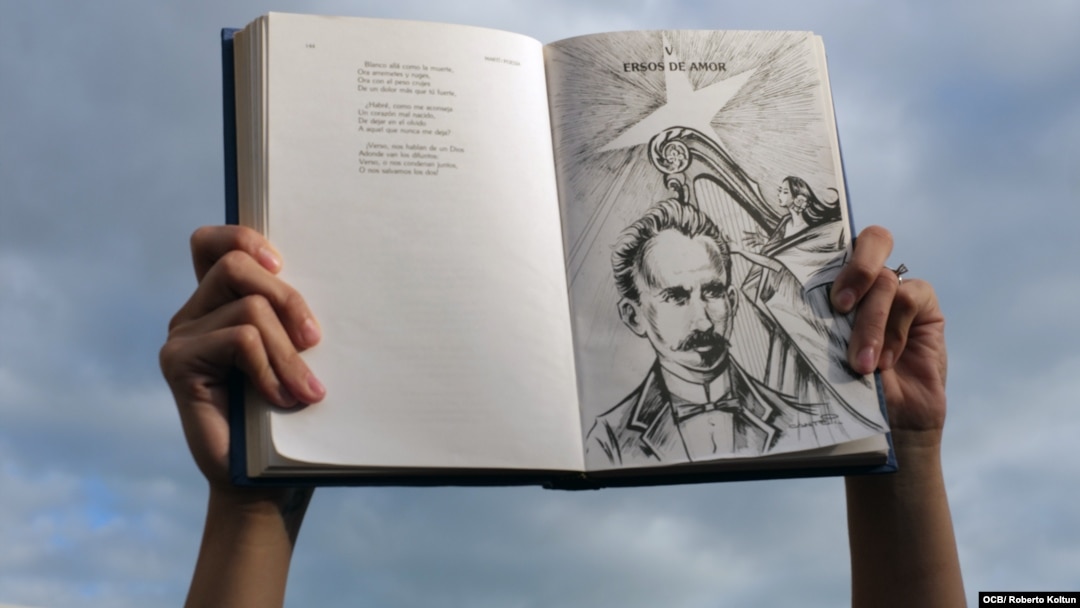 Un cubano alza un libro con la imagen y versos del apóstol José Martí. (Foto: Roberto Koltun/OCB/Archivo)