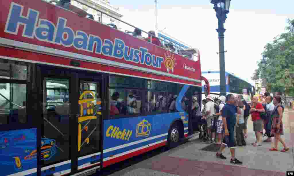 Turistas abordan un autobús turístico en La Habana.