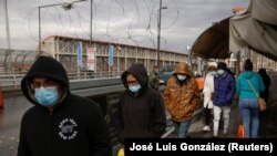 Migrantes deportados de Estados Unidos caminan hacia México por el puente fronterizo internacional Paso del Norte, en esta foto tomada desde Ciudad Juárez, México el 29 de enero de 2021. REUTERS/José Luis González.