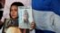 Una niña sostiene una foto durante una conferencia de prensa en la sede de la Comisión Permanente de Derechos Humanos de Nicaragua (CPDH) para exigir la liberación de los manifestantes detenidos durante las protestas del año pasado contra el gobierno del 