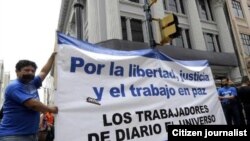 Empleados del diario El Universo portan un cartel