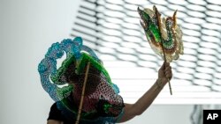 Imagen de Documenta, feria de arte contemporáneo que se celebra cada cinco años. En esta imagen, la artista germana Christine Falk hace una performance con títeres de Tailandia. (AP Photo/Martin Meissner).