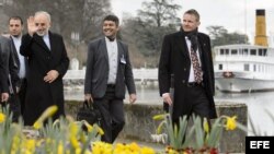 El director de la Organización de Energía Atómica de Irán, Ali-Akbar Salehi (i), saluda a la prensa a su paso por el lago Ginebra.