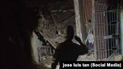 Un rescatista observa con la luz de una linterna los daños en las viviendas derrumbadas. (José Luis Tan/Facebook)