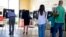 Electores hacen cola para emitir su voto durante los comicios presidenciales en un colegio electoral de Miami, Florida.,
