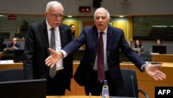 El ministro de Asuntos Exteriores de la Autoridad Palestina, Riyad al-Maliki (izq.), y el jefe de política exterior de la Unión Europea, Josep Borrell, llegan a la reunión de ministros de Asuntos Exteriores de la UE, en Bruselas. (Virginia Mayo/Pool/AFP)