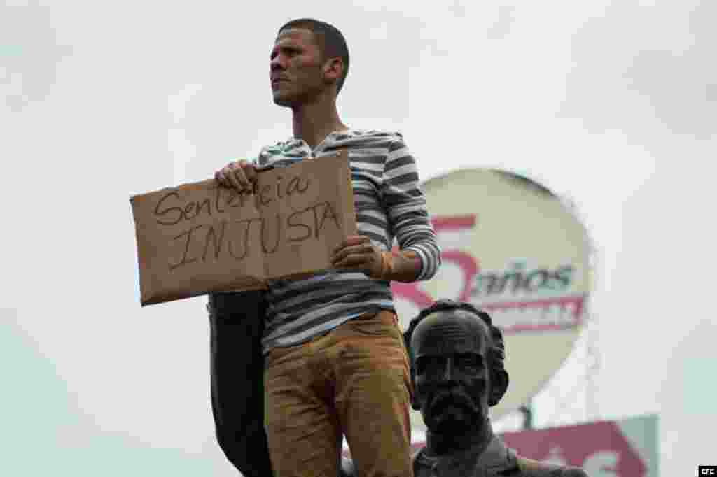 Un hombre sostiene un cartel con el mensaje &quot;sentencia injusta&quot; en referencia a la condena de 13 años y nueve meses de prisión, dictada contra el dirigente opositor.