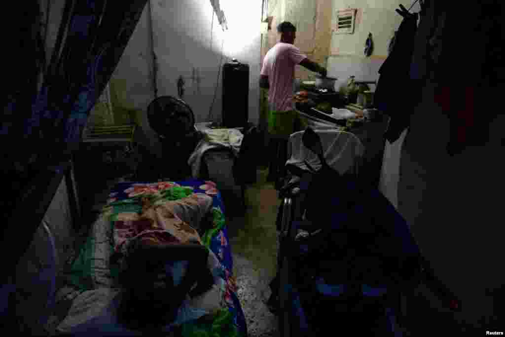 Oniel Torres, de 44 años, prepara la cena para su esposa embarazada, Claudia Artis, de 24 años, en su casa, mientras la red eléctrica nacional de Cuba colapsaba nuevamente el lunes —cuando el gobierno intentaba restablecer el suministro tras un apagón generalizado el domingo— en La Habana, Cuba, el 3 de agosto de 2026. REUTERS/Norlys Perez